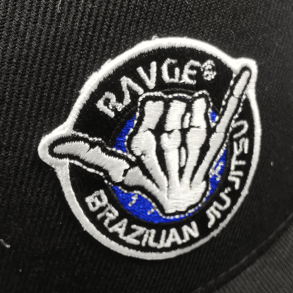 Gorra snapback RAVGE BJJ color negro con logo RVG bordado, estilo urbano inspirado en artes marciales.