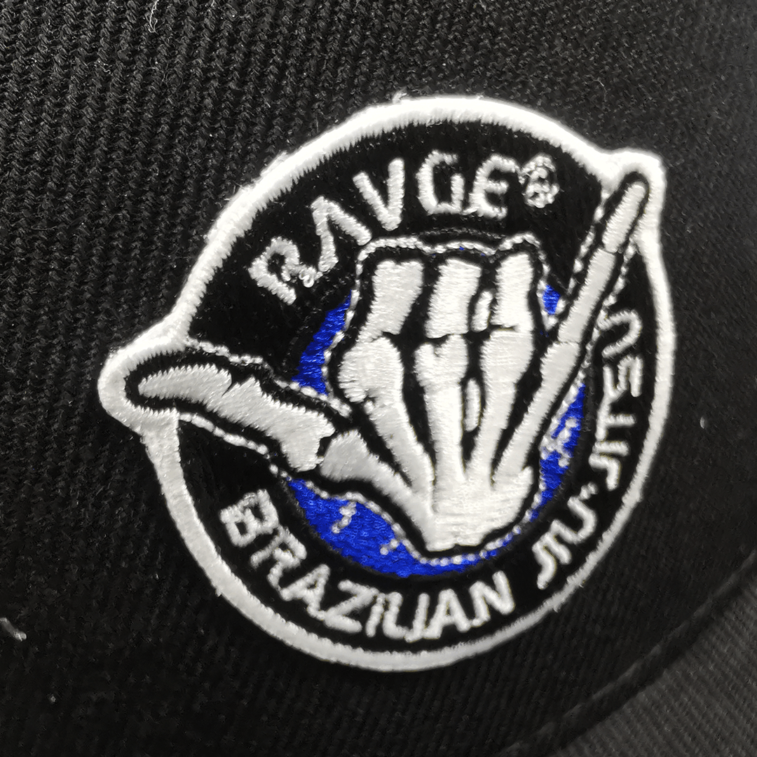 Gorra snapback RAVGE BJJ color negro con logo RVG bordado, estilo urbano inspirado en artes marciales.