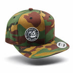 Gorra snapback RAVGE Martial Clan camo con logo RVG bordado, estilo urbano inspirado en artes marciales.